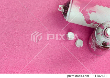 Some used pink aerosol spray cans and nozzles with paint drips lies on a blanket of soft and furry light pink fleece fabric. Classic female design color. Graffiti hooliganism concept Some used pink aerosol spray cans and nozzles with paint drips lies on a blanket of soft and furry light pink fleece fabric. Classic female design color. Graffiti hooliganism concept 81182612