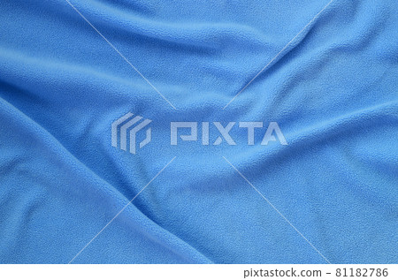 The blanket of furry blue fleece fabric. A background of light blue soft plush fleece material with a lot of relief folds The blanket of furry blue fleece fabric. A background of light blue soft plush fleece material with a lot of relief folds 81182786