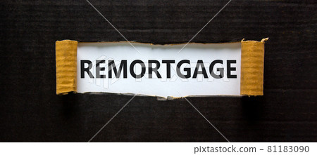 Remortgage symbol. The word 'remortgage' appearing behind torn black paper. Beautiful black background. Business and remortgage concept. 81183090