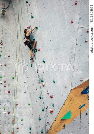 One cute teen girl with climbing equipment practicing on rock wall outdoors. Little hiker. Active lifestyle concept One cute teen girl with climbing equipment practicing on rock wall outdoors. Little hiker. Active lifestyle concept 81183691
