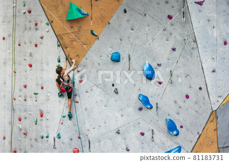 One cute teen girl with climbing equipment practicing on rock wall outdoors. Little hiker. Active lifestyle concept One cute teen girl with climbing equipment practicing on rock wall outdoors. Little hiker. Active lifestyle concept 81183731