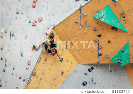 One cute teen girl with climbing equipment practicing on rock wall outdoors. Little hiker. Active lifestyle concept One cute teen girl with climbing equipment practicing on rock wall outdoors. Little hiker. Active lifestyle concept 81183763