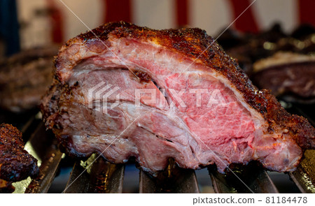 large cut of beef roasted on the barbecue grill 81184478