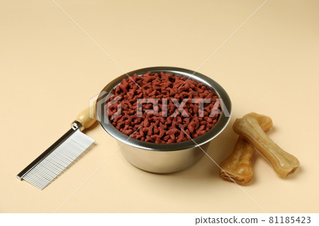 Pet feed and hair brush on beige background 81185423