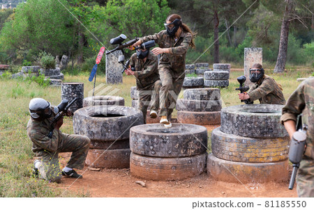 Two active opposing teams with guns playing paintball Two active opposing teams with guns playing paintball 81185550