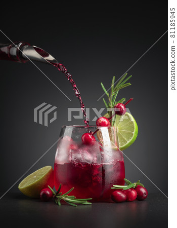 Cranberry cocktail garnished with berries, lime, and rosemary. Cranberry cocktail garnished with berries, lime, and rosemary. 81185945