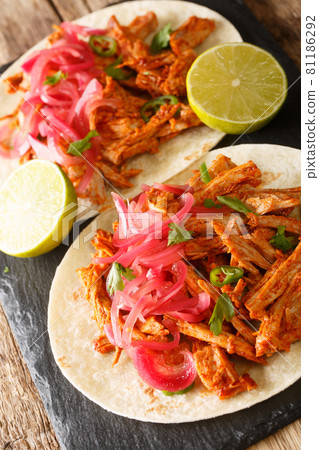 Cochinita pibil also puerco pibil or cochinita con achiote is a traditional Mexican slow-roasted pork dish from the Yucatan closeup on the table. Vertical 81186292