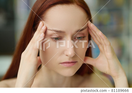 Sad adult pretty woman suffering from a temporal pain Sad adult pretty woman suffering from a temporal pain 81189666