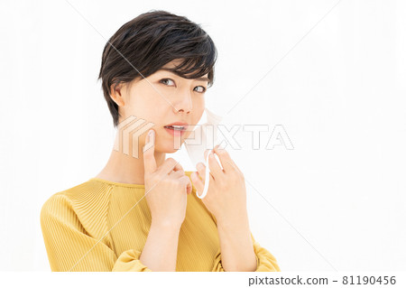 A young woman suffering from rough skin caused by a mask in front of a white curtain 81190456