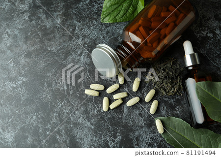 Concept of herbal medicine pills on black smokey table, space for text Concept of herbal medicine pills on black smokey table, space for text 81191494