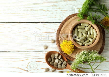 Concept of herbal medicine pills on white wooden table, space for text 81191495