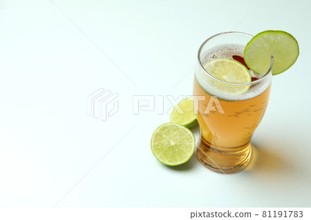 Glass of beer with lime on white background Glass of beer with lime on white background 81191783