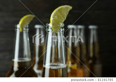 Beer with lime on wooden background, close up Beer with lime on wooden background, close up 81191785