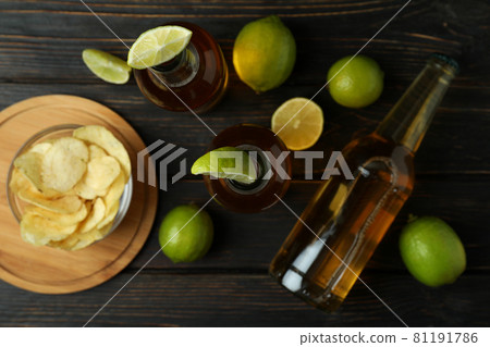Beer with lime and chips on wooden background 81191786