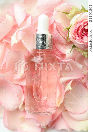 Bottle with rose essential oil on rose petals background 81191861