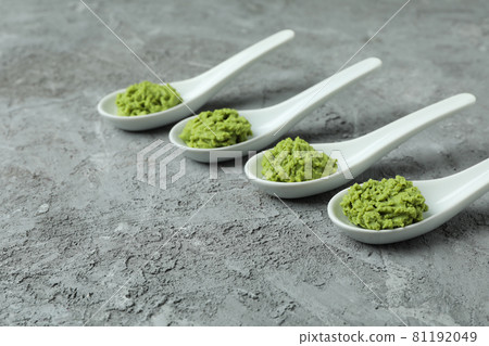 Ceramic spoons with wasabi on gray textured background 81192049