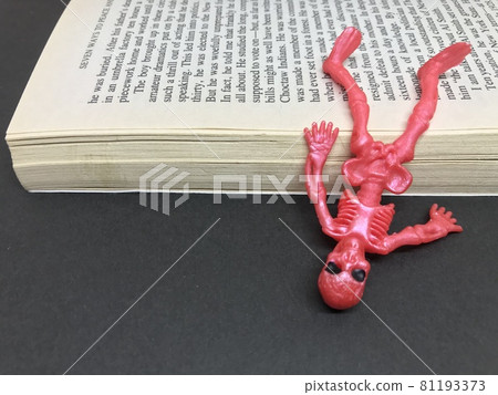 夾在書之間的頭骨和骷髏。公司奴隸,工人聖人形象 夾在書之間的頭骨和骷髏。公司奴隸,工人聖人形象 81193373