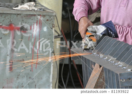 SELANGOR, MALAYSIA -AUGUST 29, 2016: Construction workers cutting reinforcement bar using mobile grinder at the construction site in Selangor, Malaysia. SELANGOR, MALAYSIA -AUGUST 29, 2016: Construction workers cutting reinforcement bar using mobile grinder at the construction site in Selangor, Malaysia. 81193922