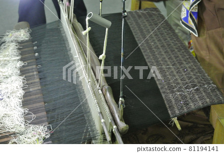 KUALA LUMPUR, MALAYSIA -JUNE 25, 2016: Traditional weaving machine operate by a Malay woman. Produced special cloth called Songket. KUALA LUMPUR, MALAYSIA -JUNE 25, 2016: Traditional weaving machine operate by a Malay woman. Produced special cloth called Songket. 81194141