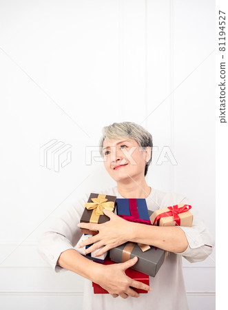 A mature woman in Asia is wearing a gift box on a white background. A mature woman in Asia is wearing a gift box on a white background. 81194527