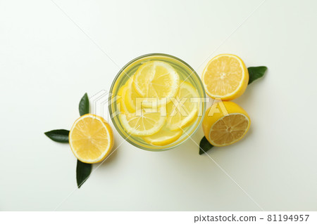 Glass of lemonade and lemons on white background 81194957