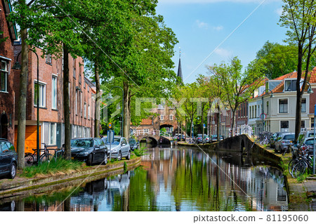 Cars on canal embankment in street of Delft. Delft, Netherlands 81195060