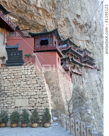 The Hanging Temple or Hanging Monastery near Datong in Shanxi Province, China. The Hanging Temple on a cliff seen from the side with stone sign showing the name of the site. 81195123