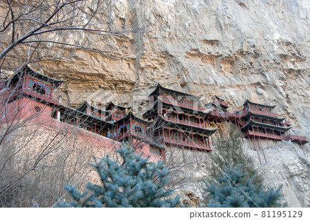 The Hanging Temple or Hanging Monastery near Datong in Shanxi Province, China. View of the Hanging Temple with trees in the foreground. The temple is a major tourist sight near Datong. 81195129