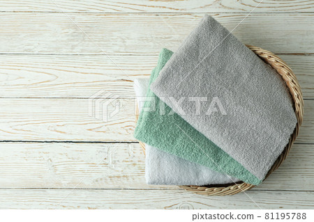 Basket with clean towels on white wooden table 81195788