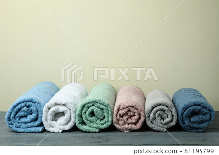 Clean rolled towels against beige background, space for text 81195799