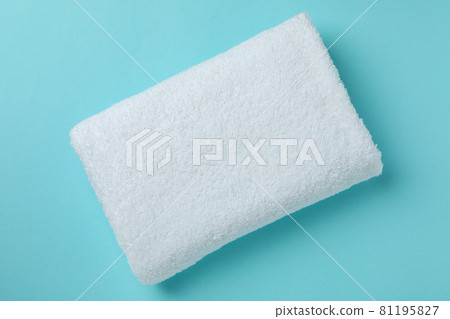 White folded towel on blue background, top view White folded towel on blue background, top view 81195827
