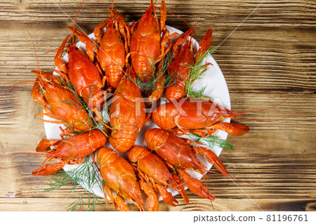 Boiled crayfish in plate on wooden table. Top view 81196761