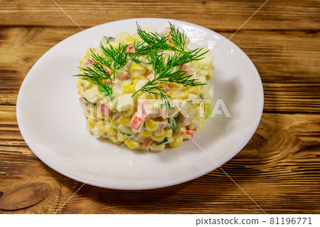 Salad with crab sticks, sweet corn, cucumber, eggs and mayonnaise on wooden table Salad with crab sticks, sweet corn, cucumber, eggs and mayonnaise on wooden table 81196771