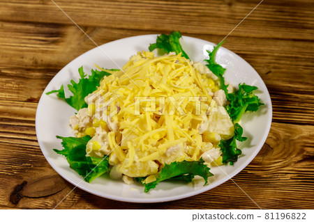 Festive salad with chicken breast, sweet corn, canned pineapple, cheese and mayonnaise on wooden table 81196822