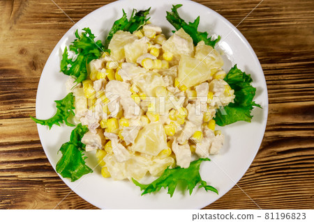 Festive salad with chicken breast, sweet corn, canned pineapple and mayonnaise on wooden table Festive salad with chicken breast, sweet corn, canned pineapple and mayonnaise on wooden table 81196823