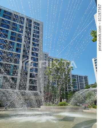 Square fountain between buildings 81197567