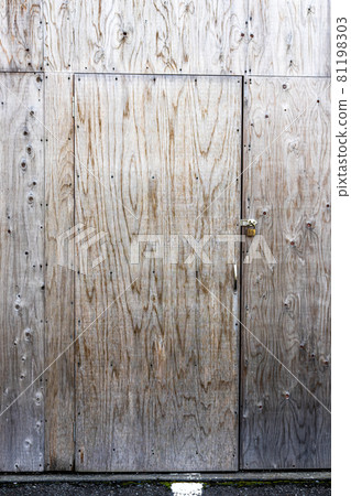 Wooden, plywood door, in plywood wall, with padlock. 81198303