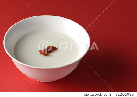 A simple almond tofu with goji berries on a red background 81201080