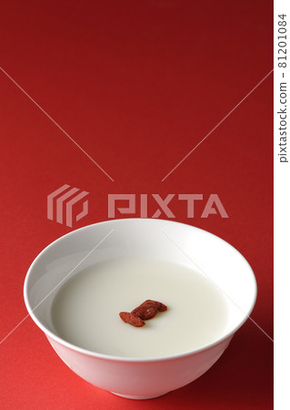 A simple almond tofu with goji berries on a red background 81201084