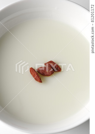 A bird's-eye view of a simple almond tofu with goji berries on a white background 81201172