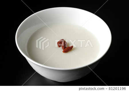 A simple almond tofu with goji berries on a black background 81201196