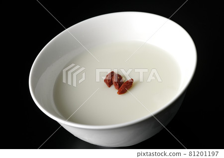 A simple almond tofu with goji berries on a black background 81201197