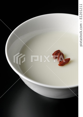 A simple almond tofu with goji berries on a black background 81201211