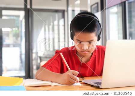 Young collage student using computer and mobile device studying online. Young collage student using computer and mobile device studying online. 81203540