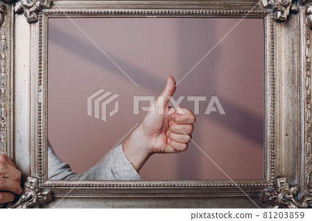 Thumbs up young man standing with picture frame at studio. Thumbs up young man standing with picture frame at studio. 81203859