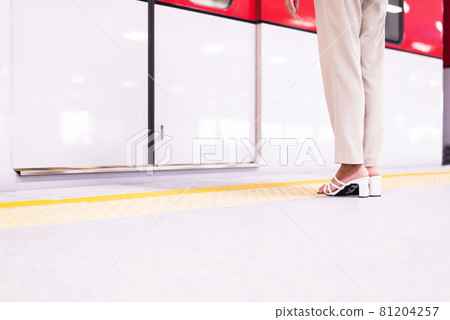 Woman standing behind safety yellow line for waiting for the train Woman standing behind safety yellow line for waiting for the train 81204257