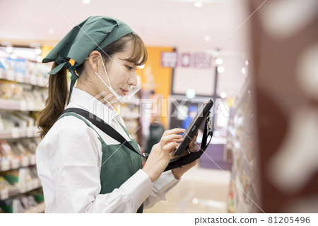 A female employee with a mouse shield who manages inventory at a supermarket 81205496