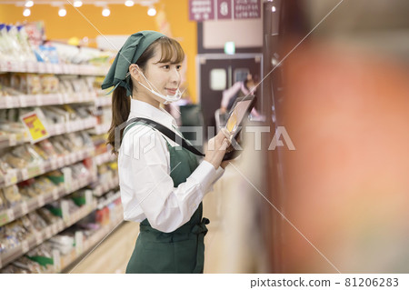 A female employee with a mouse shield who manages inventory at a supermarket 81206283
