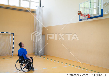 a war invalid in a wheelchair trains with a ball at a basketball club in training with professional sports equipment for the disabled. the concept of sport for people with disabilities 81206451