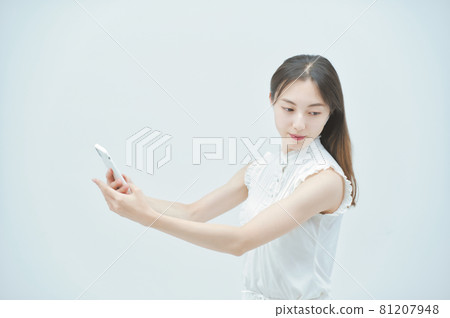 一個年輕女子拿著智能手機跳舞 81207948